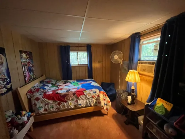 a bedroom with a bed and dresser with mirror