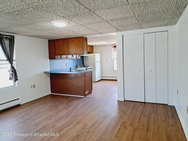 a view of a kitchen with wooden floor and a sink