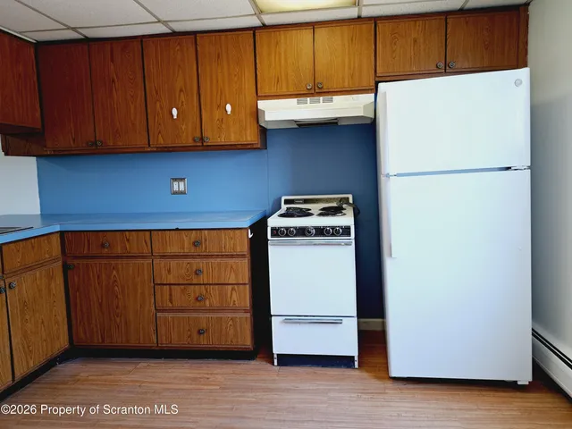 a kitchen with a cabinets and a refrigerator
