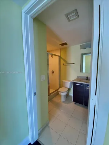 a bathroom with a glass door shower a sink and a toilet