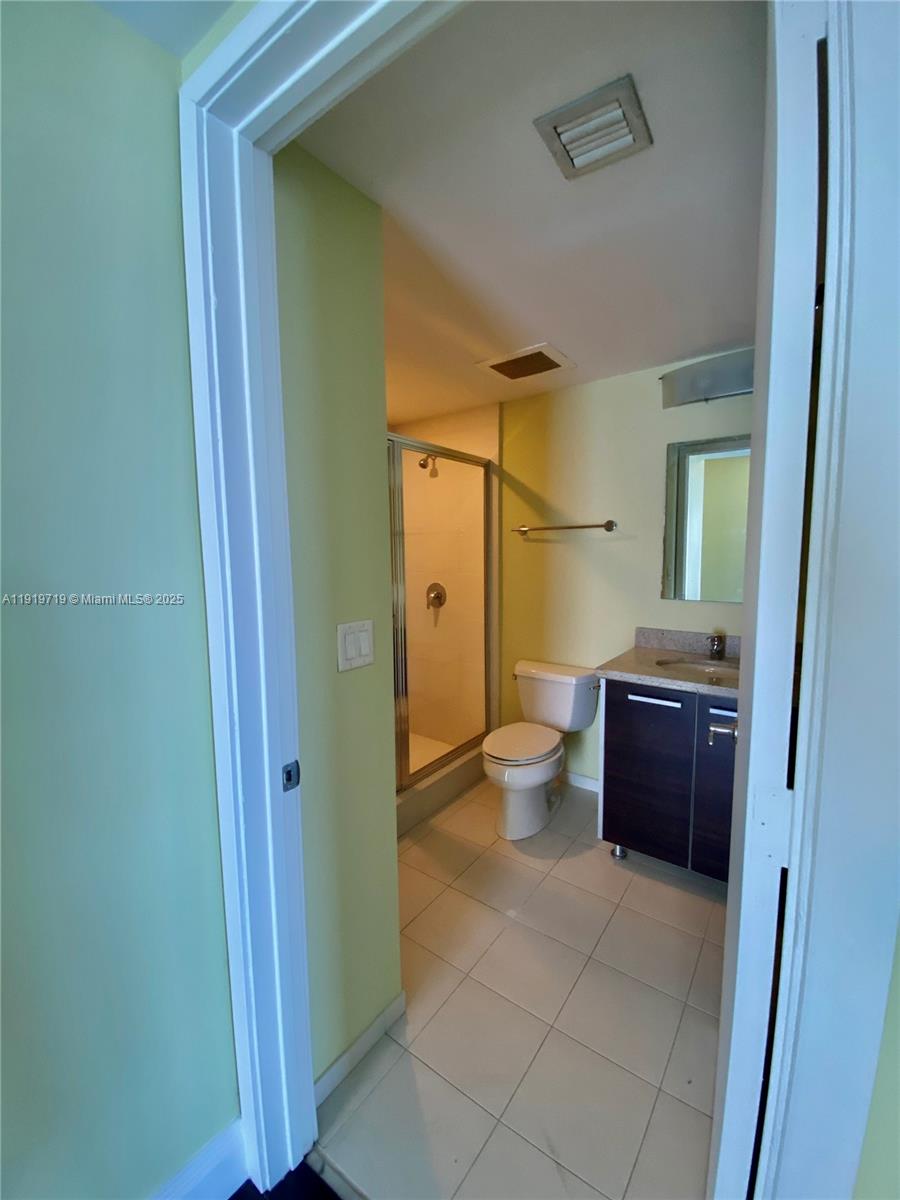 185 Southwest 7th Street, Unit 2011 Miami, FL 33130 - Photo 12 of 30 a bathroom with a glass door shower a sink and a toilet