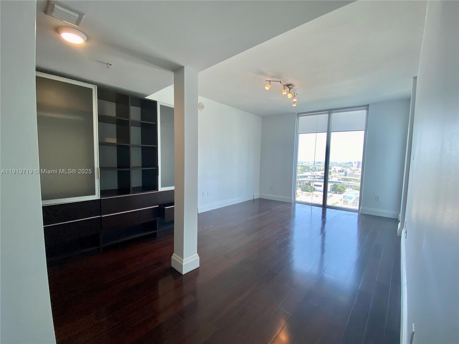 185 Southwest 7th Street, Unit 2011 Miami, FL 33130 - Photo 5 of 30 an empty room with wooden floor and windows