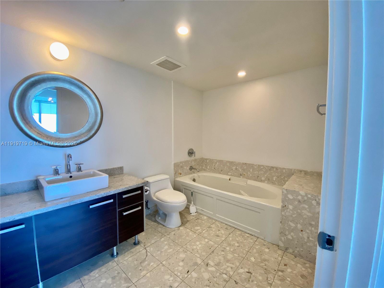 185 Southwest 7th Street, Unit 2011 Miami, FL 33130 - Photo 7 of 30 a bathroom with a toilet a sink and a mirror