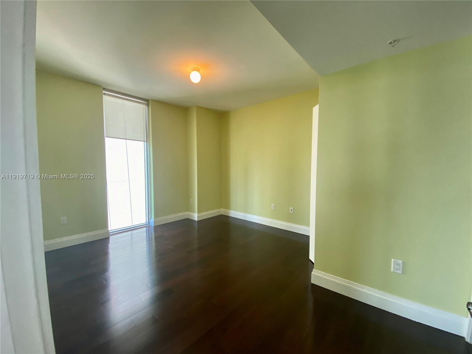 185 Southwest 7th Street, Unit 2011 Miami, FL 33130 - Photo 10 of 30 a view of an empty room with wooden floor and a window