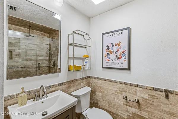 a bathroom with a sink mirror and a toilet