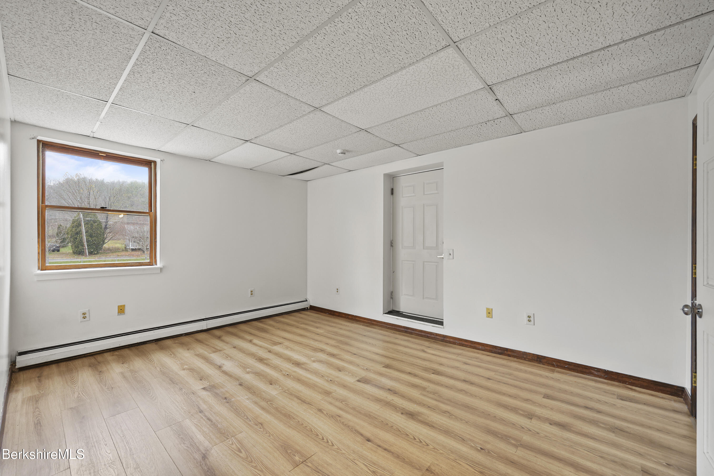 55 Crystal Street, Unit 8 Lenox, MA 01242 - Photo 9 of 12 a view of an empty room with wooden floor and a window