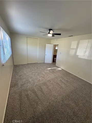an empty room with windows and closet