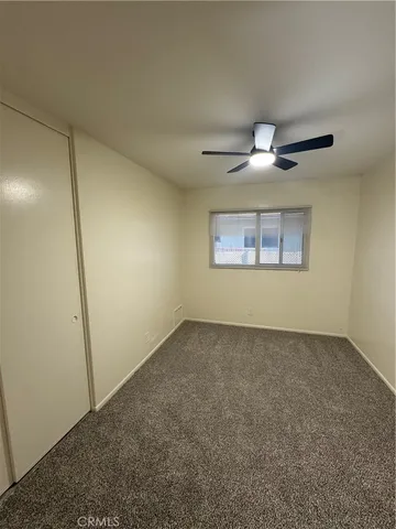 an empty room with a ceiling fan and a window