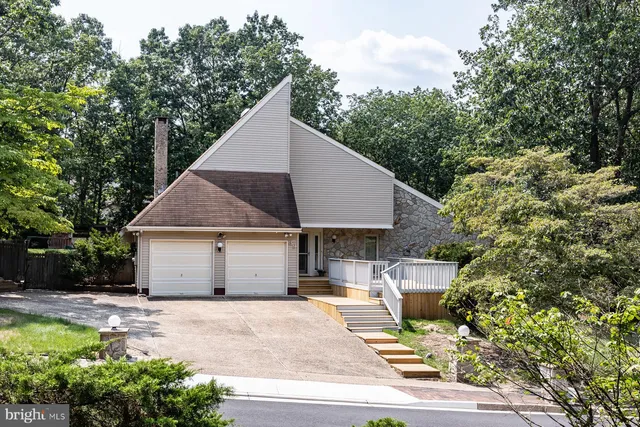 a view of a house with backyard and trees