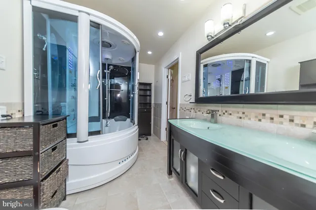 a bathroom with a tub shower and mirror