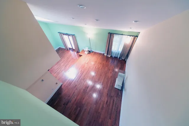 a view of a hallway with wooden floor windows and a chandelier
