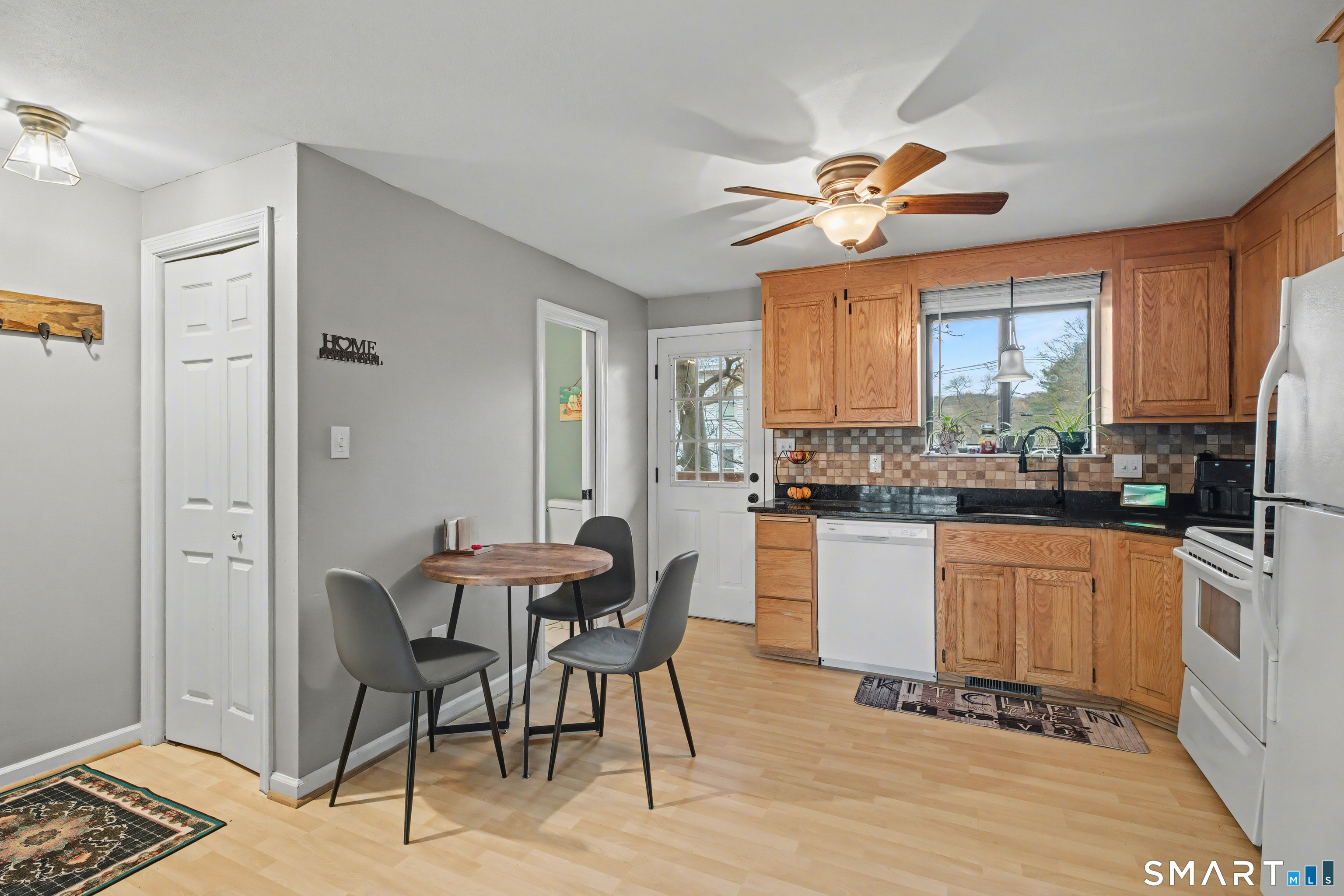 120 West Main Street, Unit 206 Meriden, CT 06451 - Photo 12 of 37 a kitchen with stainless steel appliances kitchen island granite countertop a dining table chairs and a refrigerator