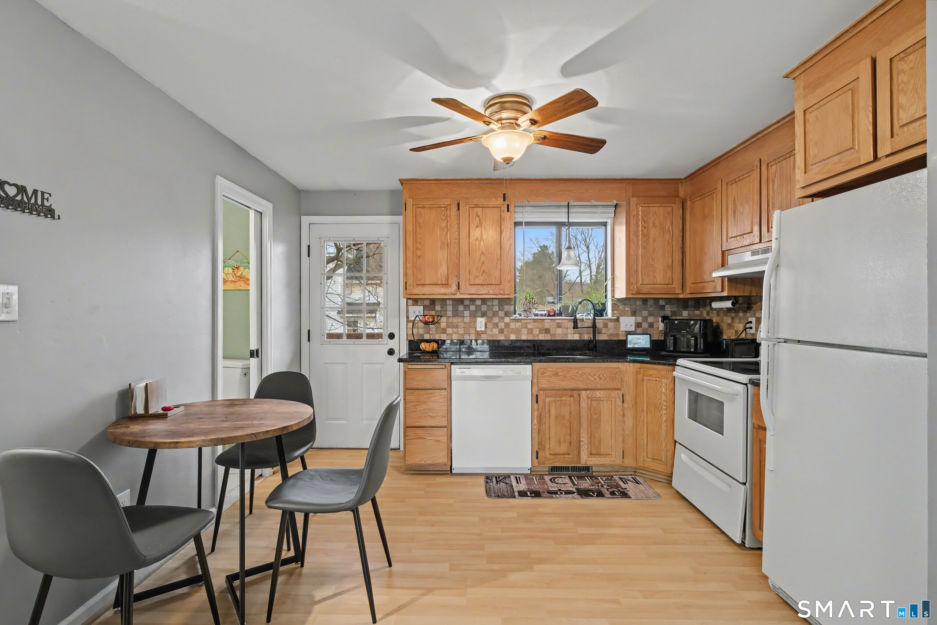 120 West Main Street, Unit 206 Meriden, CT 06451 - Photo 13 of 37 a kitchen with stainless steel appliances granite countertop a stove a refrigerator a dining table and chairs with wooden floor