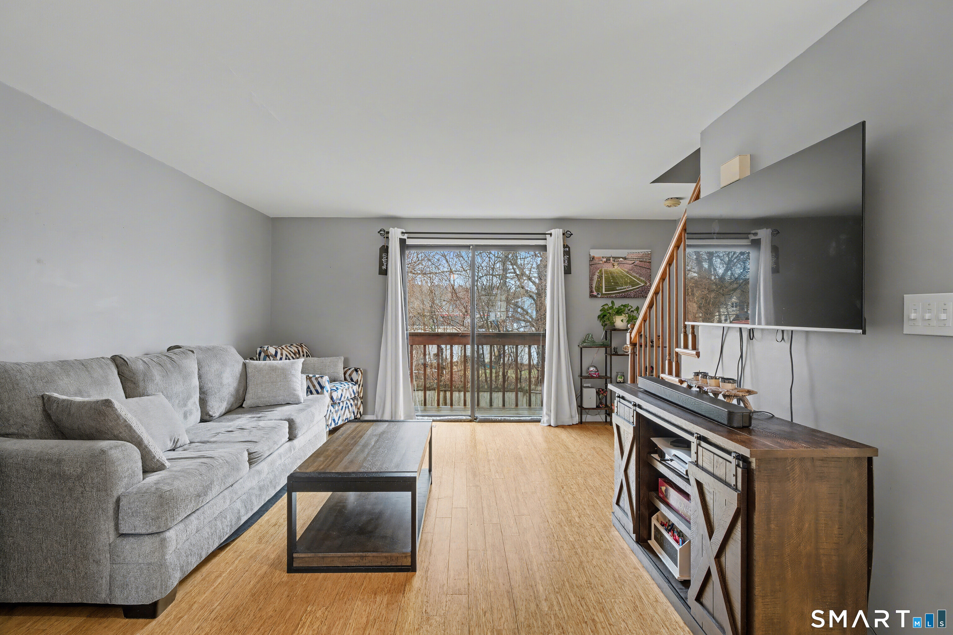 120 West Main Street, Unit 206 Meriden, CT 06451 - Photo 5 of 37 a living room with furniture a flat screen tv and a floor to ceiling window