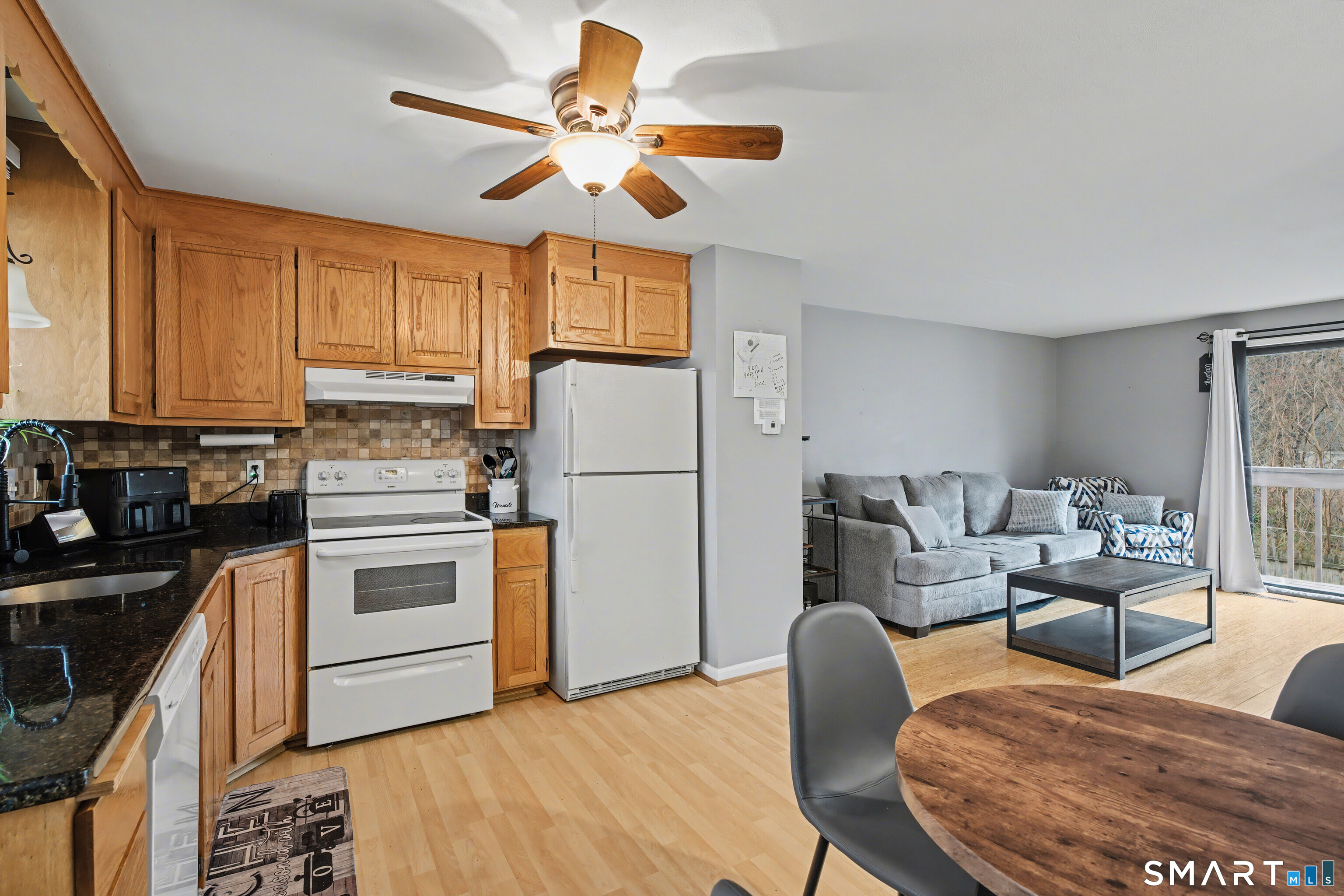 120 West Main Street, Unit 206 Meriden, CT 06451 - Photo 7 of 37 a kitchen with stainless steel appliances granite countertop a refrigerator a stove a sink dishwasher a dining table and chairs with wooden floor