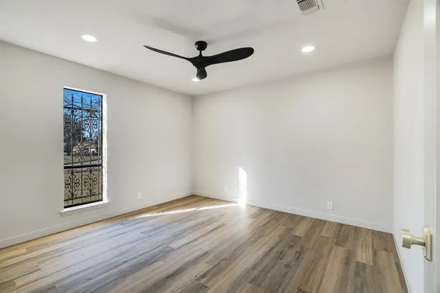 a view of empty room with wooden floor and window