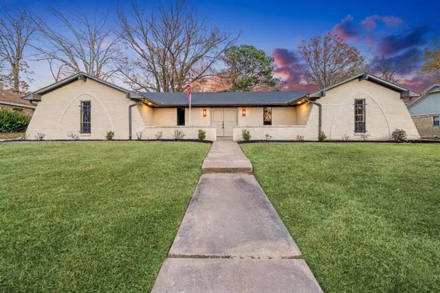 a view of a yard in front of a house with large trees