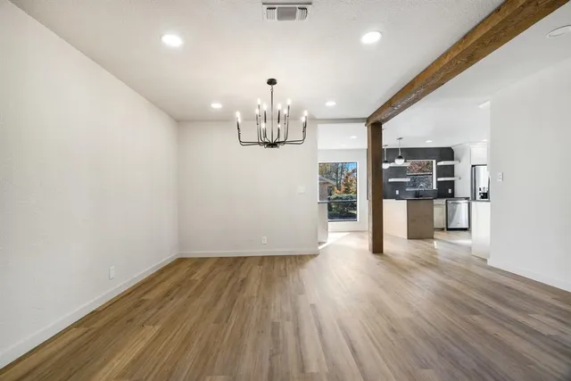 a open kitchen with stainless steel appliances granite countertop a sink and a wooden floor