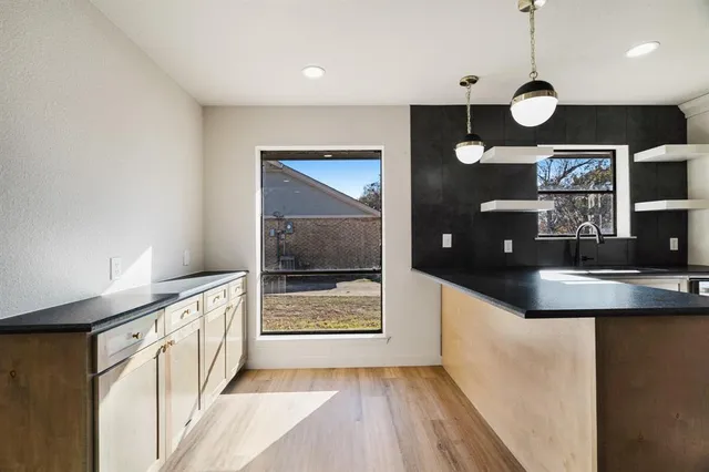 a kitchen with stainless steel appliances granite countertop a sink a stove top oven a counter space and cabinets