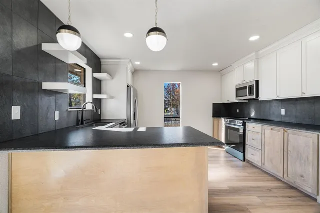 a kitchen with granite countertop a sink and cabinets