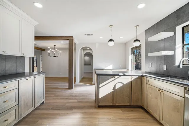 a kitchen with stainless steel appliances granite countertop a stove a sink and a microwave