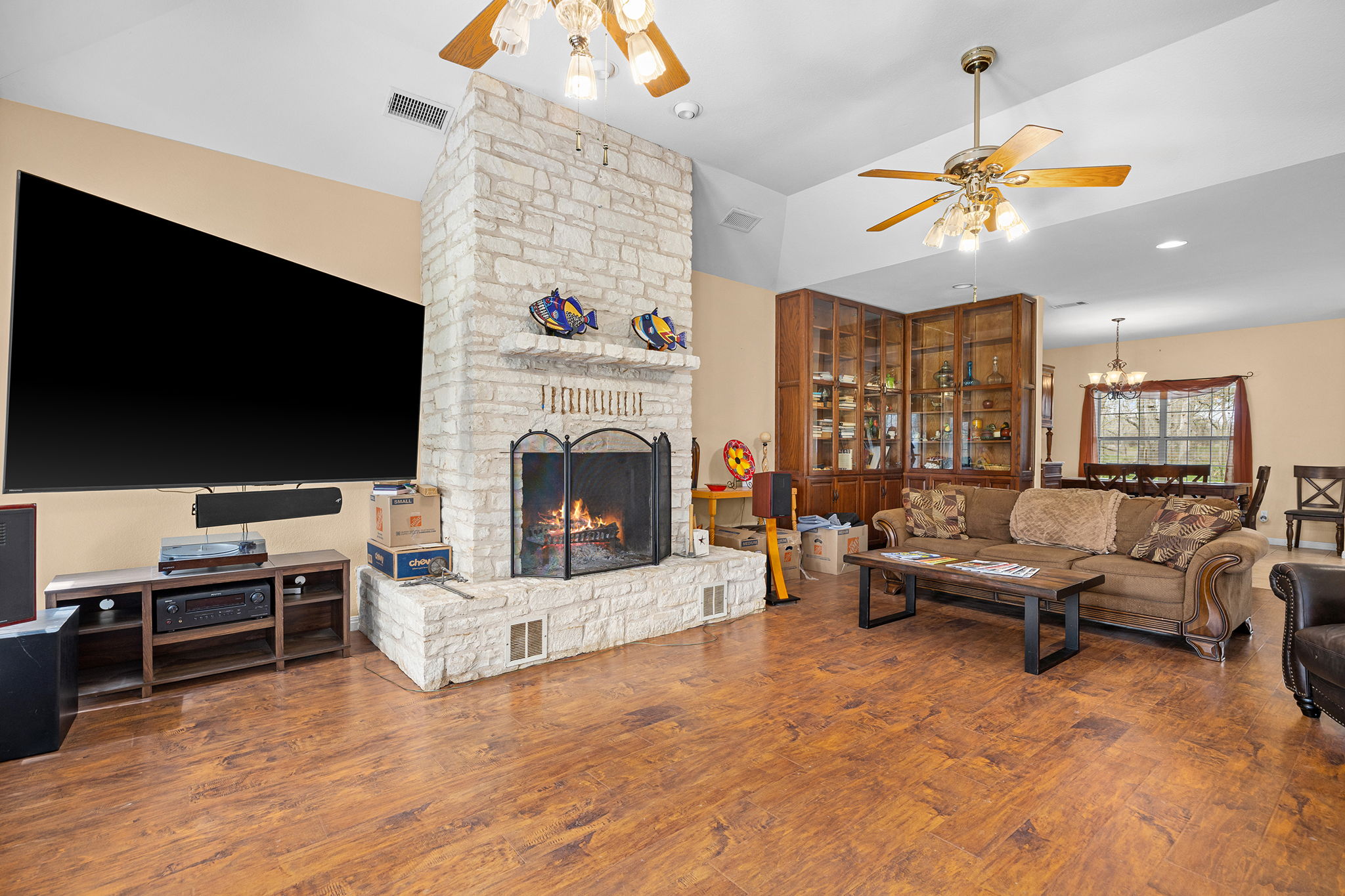 75 County Road 129 Taylor, TX 76574 - Photo 2 of 40 Living room with ceiling fan, a fireplace, dark wood finished floors, hanging lights, and lofted ceiling