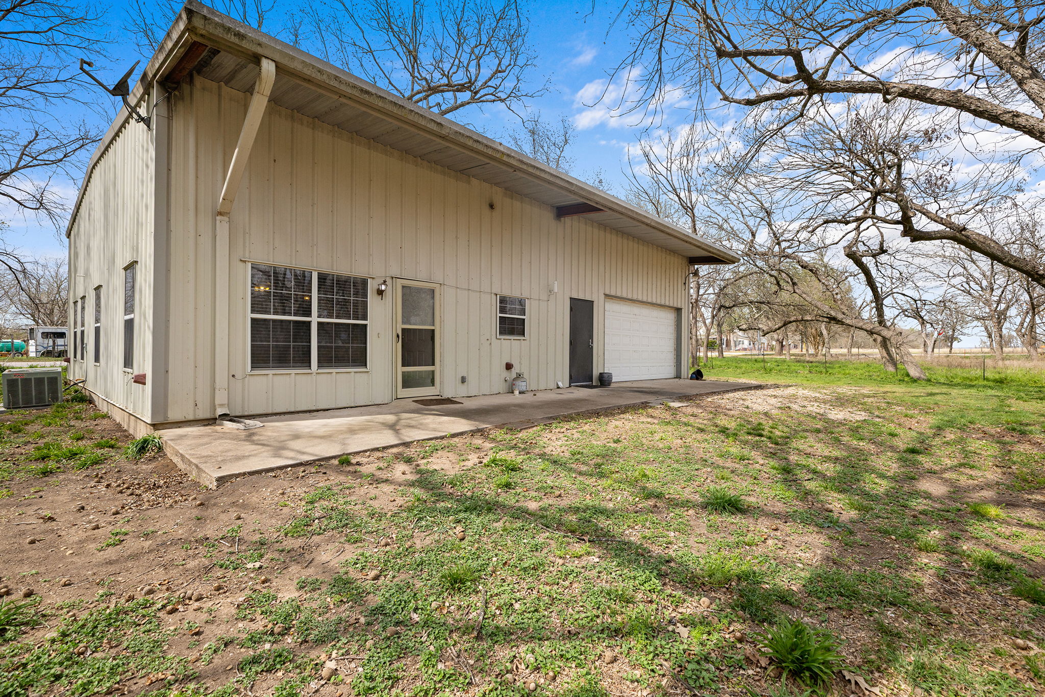 75 County Road 129 Taylor, TX 76574 - Photo 21 of 40 Back of house with a garage, a patio area, and a lawn