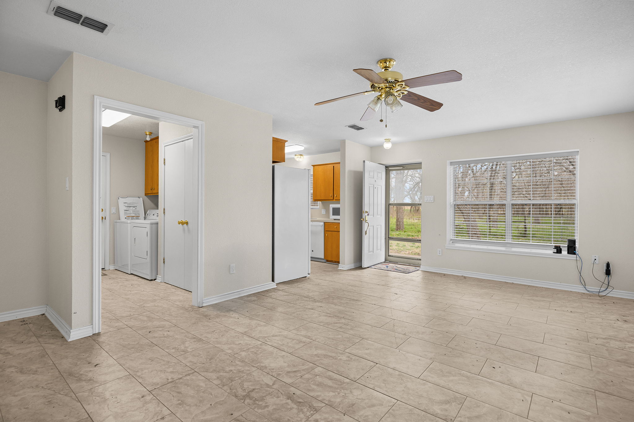 75 County Road 129 Taylor, TX 76574 - Photo 22 of 40 Unfurnished living room featuring a ceiling fan and washing machine and clothes dryer