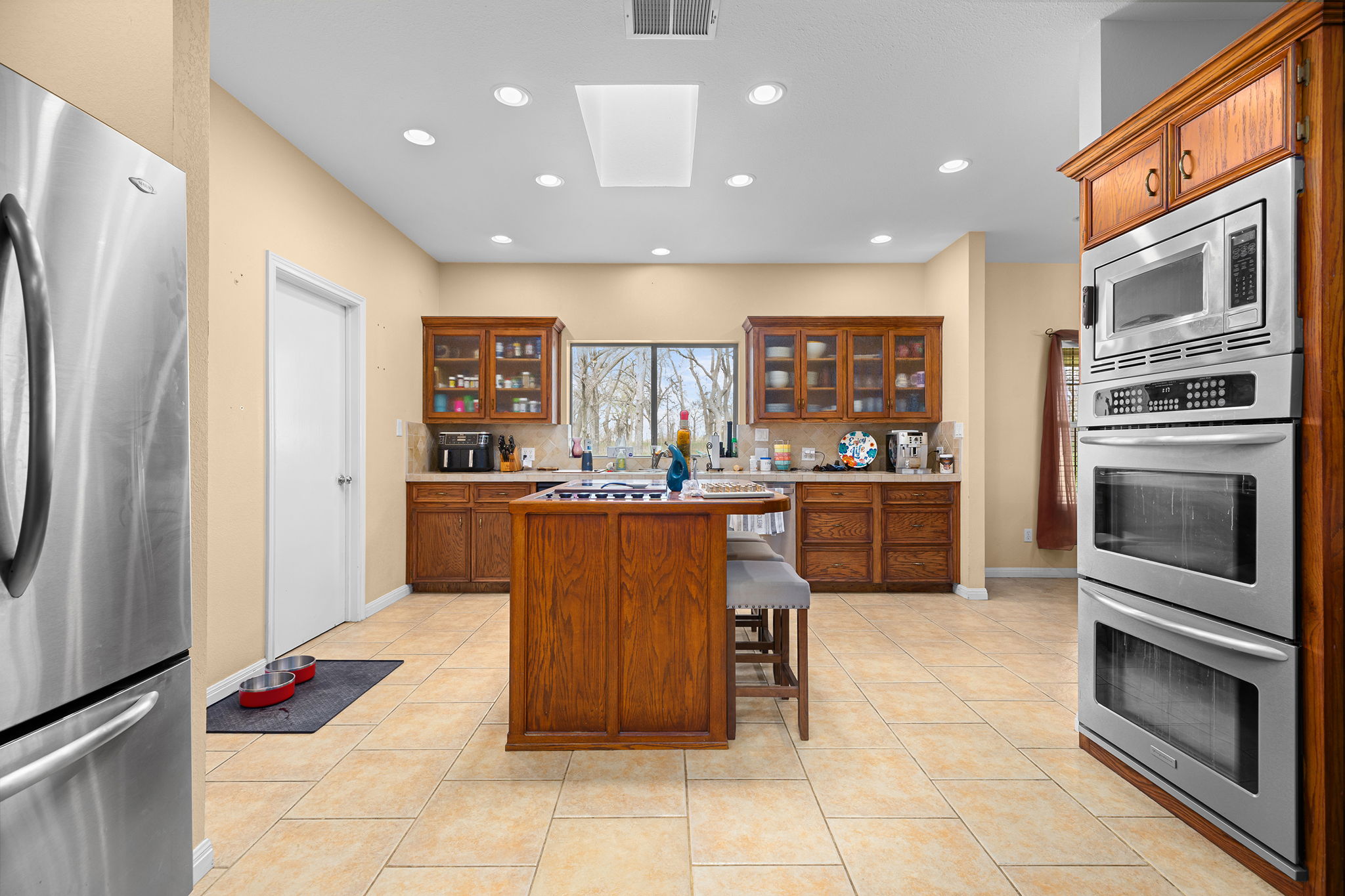 75 County Road 129 Taylor, TX 76574 - Photo 3 of 40 Kitchen with light countertops, stainless steel appliances, glass insert cabinets, wood finish cabinetry, and recessed lighting