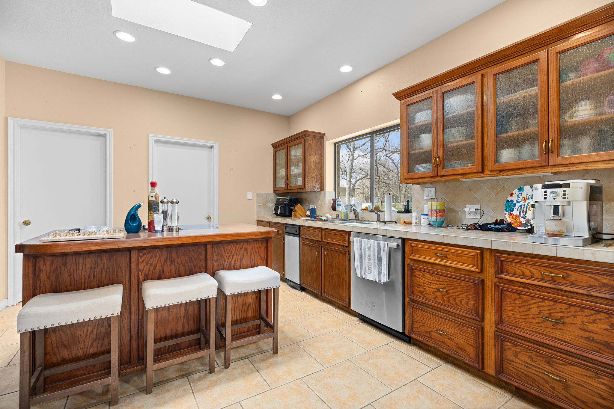 75 County Road 129 Taylor, TX 76574 - Photo 6 of 40 Kitchen featuring wood finish cabinets, a skylight, glass insert cabinets, a kitchen breakfast bar, and recessed lighting