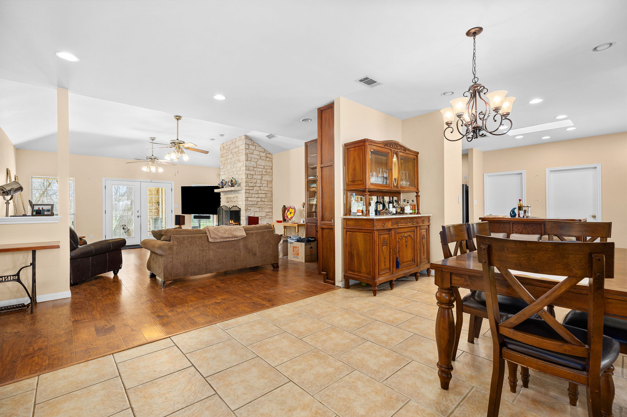 75 County Road 129 Taylor, TX 76574 - Photo 9 of 40 Dining space featuring light tile patterned flooring, a large fireplace, suspended lighting, and a ceiling fan