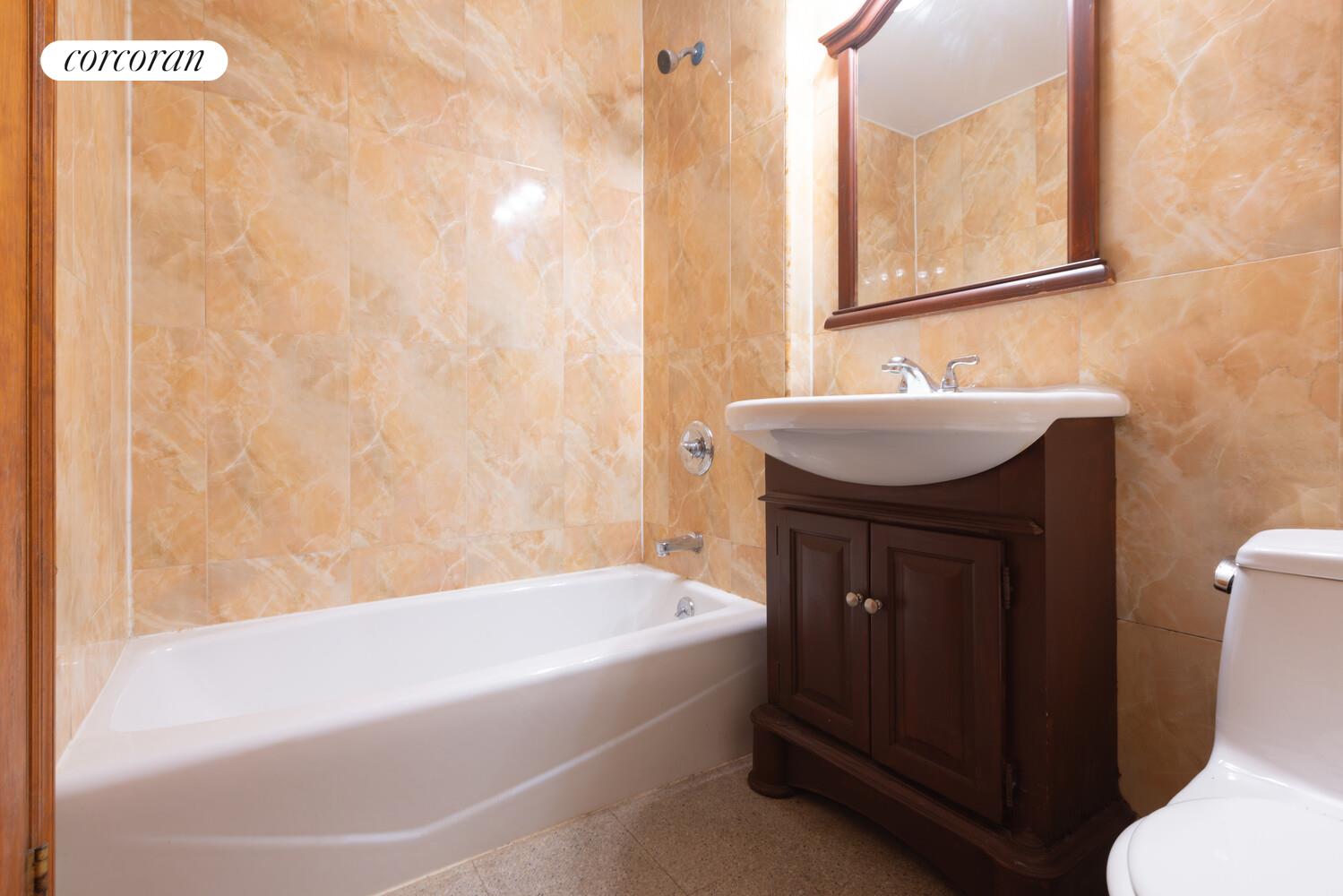 132-36 Pople Avenue, Unit BA Queens, NY 11355 - Photo 6 of 9 a bathroom with a sink and mirror with bathtub