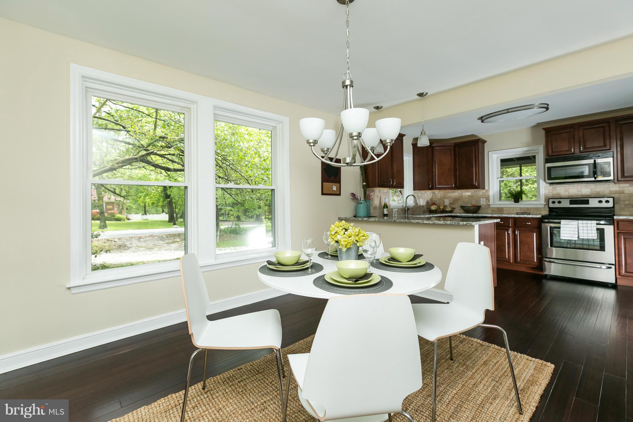 4122 Essex Road Baltimore, MD 21207 - Photo 14 of 30 a dining room with furniture a large window and wooden floor