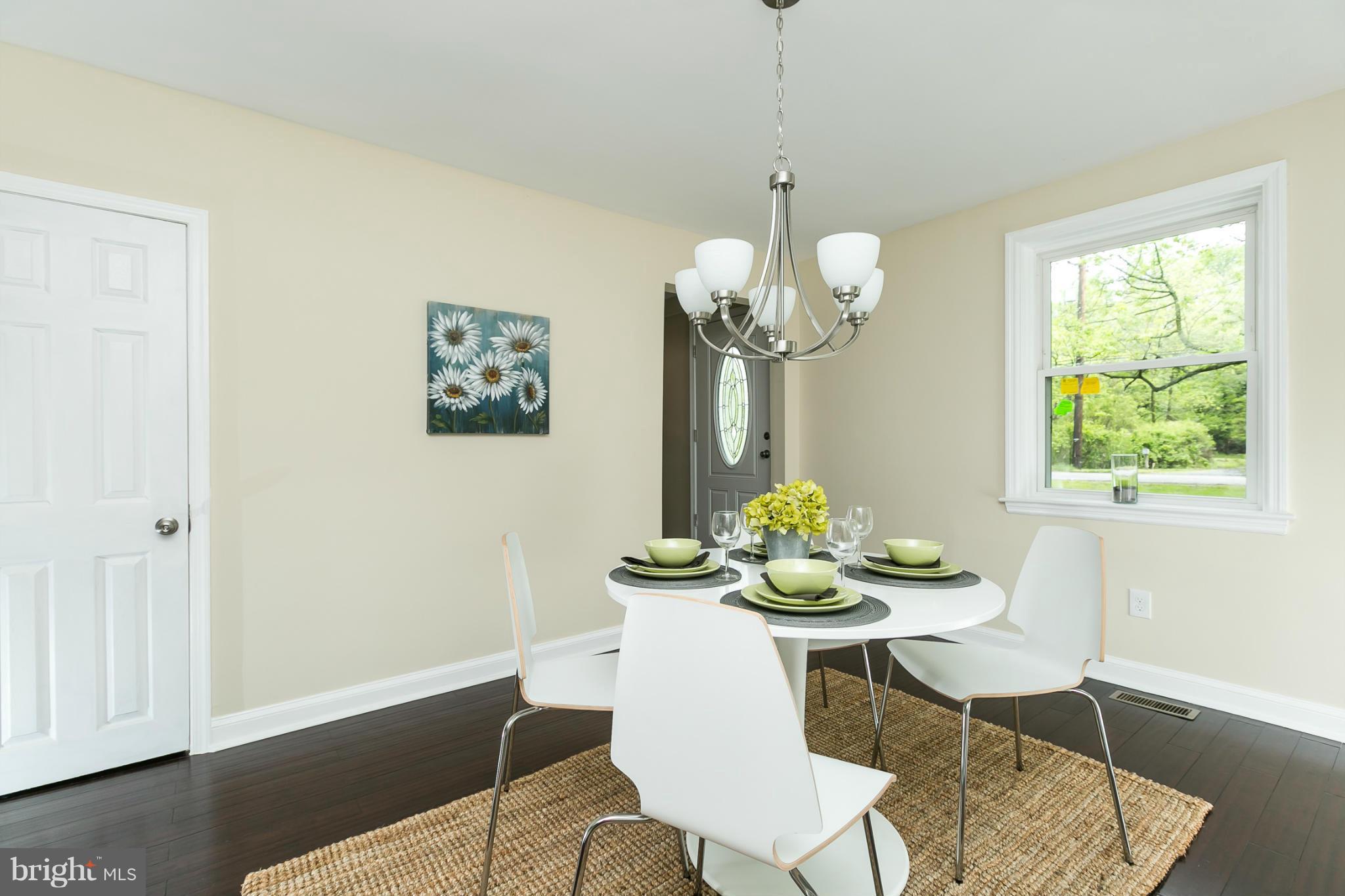 4122 Essex Road Baltimore, MD 21207 - Photo 15 of 30 a dining room with furniture a rug and a chandelier