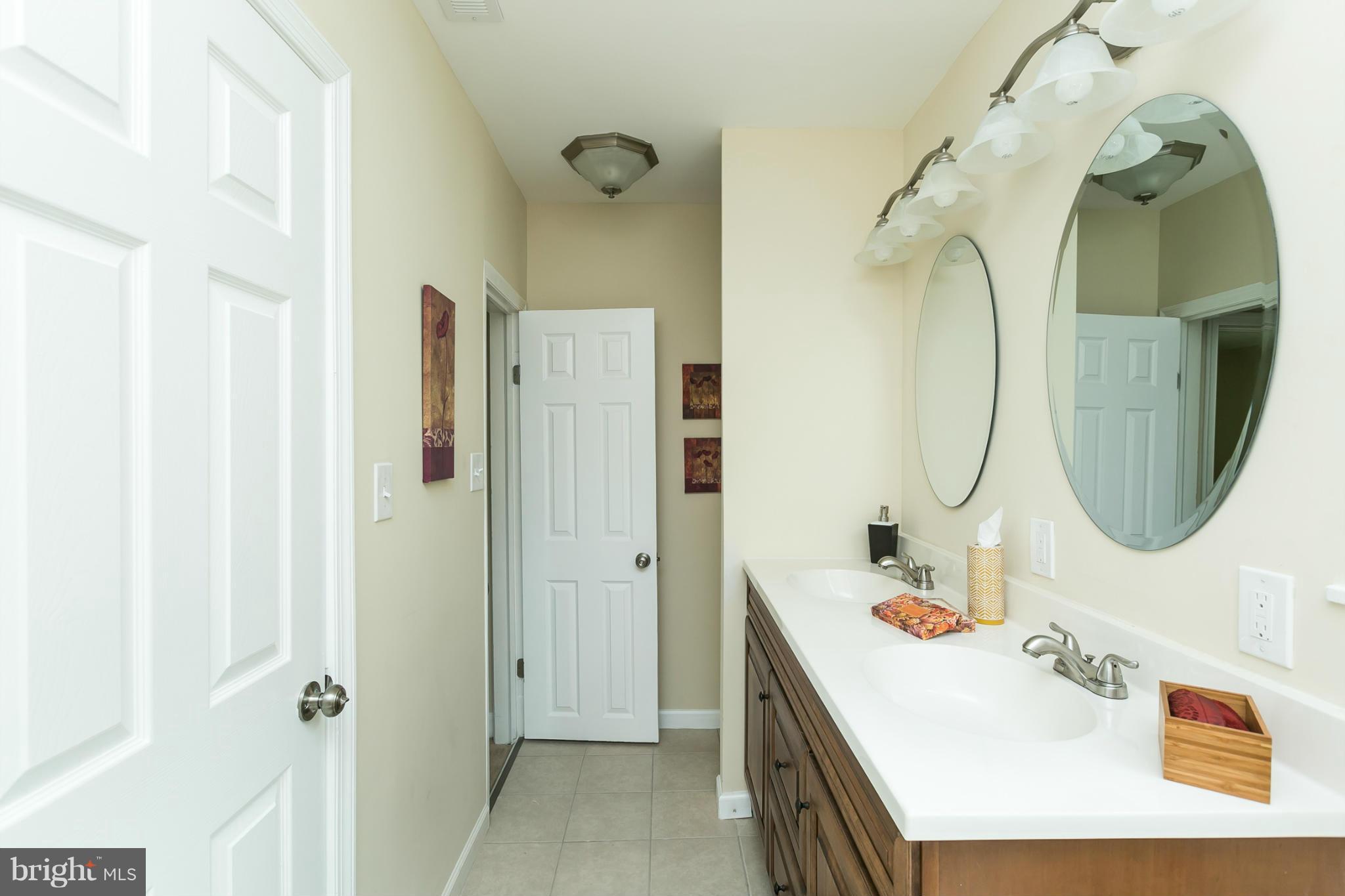4122 Essex Road Baltimore, MD 21207 - Photo 6 of 30 a bathroom with a sink double vanity and a mirror
