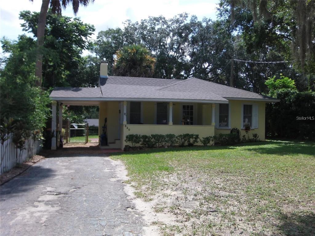320 North Rhodes Street Mount Dora, FL 32757 - Photo 1 of 33 a front view of a house with garden