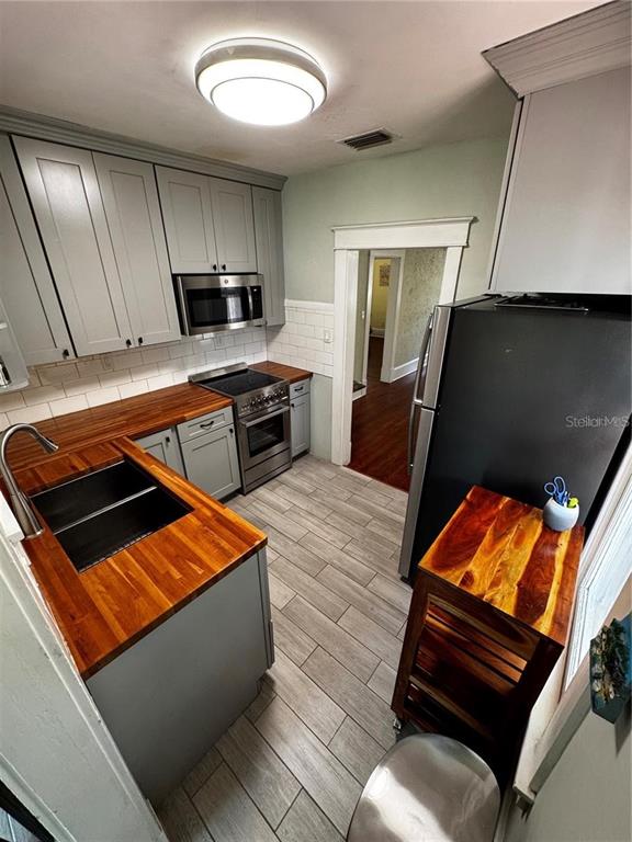 320 North Rhodes Street Mount Dora, FL 32757 - Photo 27 of 33 a kitchen with blue cabinets and black chairs