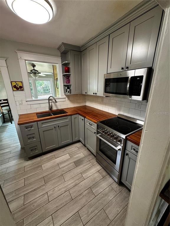 320 North Rhodes Street Mount Dora, FL 32757 - Photo 6 of 33 a kitchen with stainless steel appliances granite countertop a stove a sink and a microwave