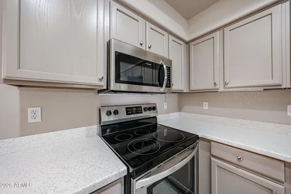 a kitchen with granite countertop white cabinets and stainless steel appliances