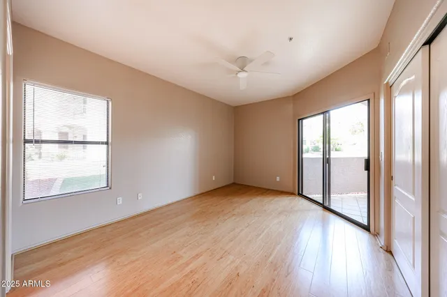an empty room with wooden floor and windows