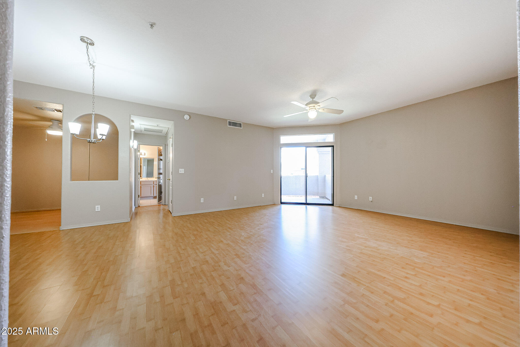 9151 West Greenway Road, Unit 162 Peoria, AZ 85381 - Photo 8 of 37 an empty room with wooden floor and windows