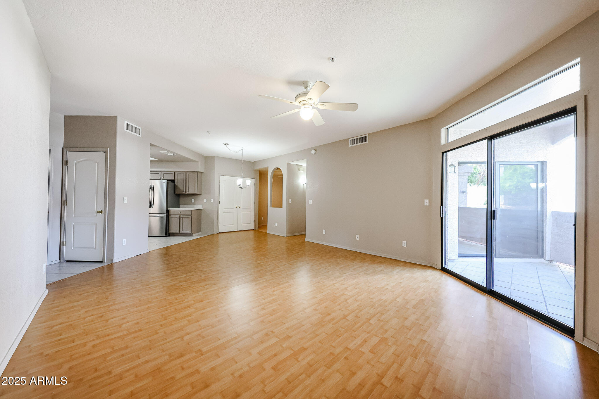 9151 West Greenway Road, Unit 162 Peoria, AZ 85381 - Photo 9 of 37 a view of empty room with wooden floor and fan