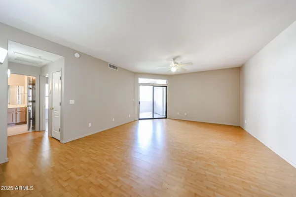 a view of empty room with wooden floor and windows