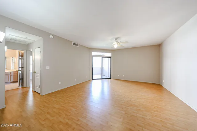 a view of empty room with wooden floor and windows