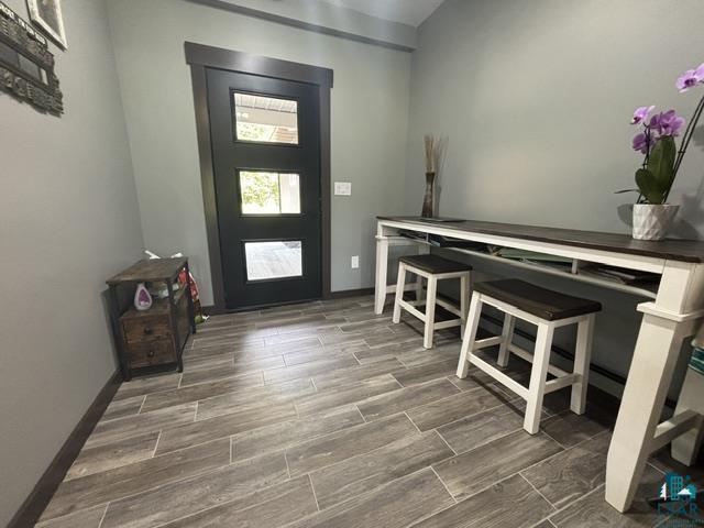 3454 Anderson Road Hibbing, MN 55746 - Photo 17 of 31 Modern entryway featuring a black paneled door with frosted glass inserts, wood-finish tile flooring, and neutral wall paint