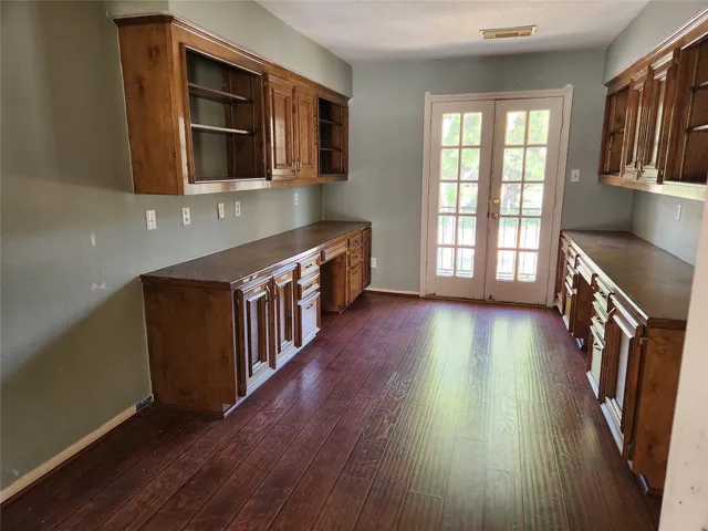 a hallway with wooden floors and wooden cabinets