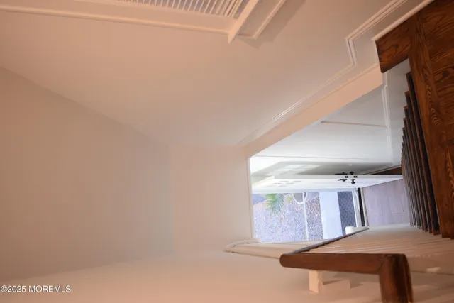 a view of a hallway with wooden floor and entryway