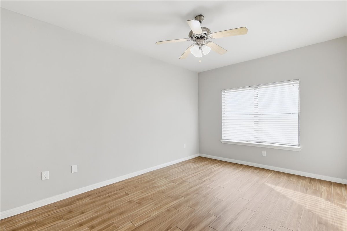 2502 Leon Street, Unit 414 Austin, TX 78705 - Photo 16 of 21 an empty room with wooden floor fan and windows