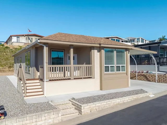 a view of a house with a small yard and wooden fence
