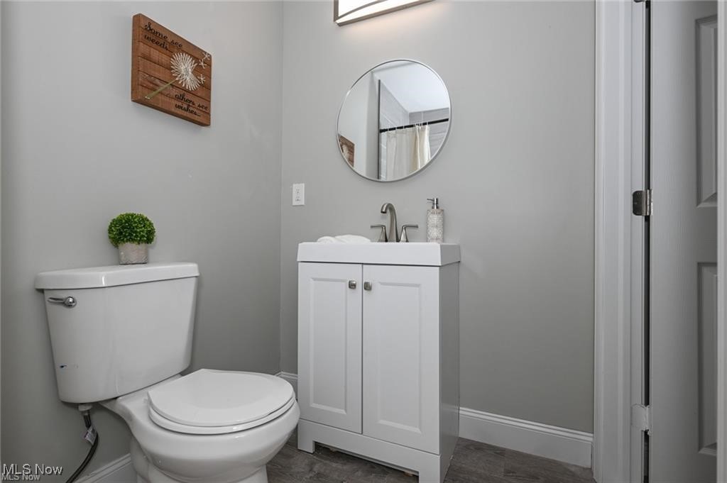 7613 Jefferson Road Ashtabula, OH 44004 - Photo 19 of 35 Bathroom featuring vanity, hardwood / wood-style flooring, and toilet